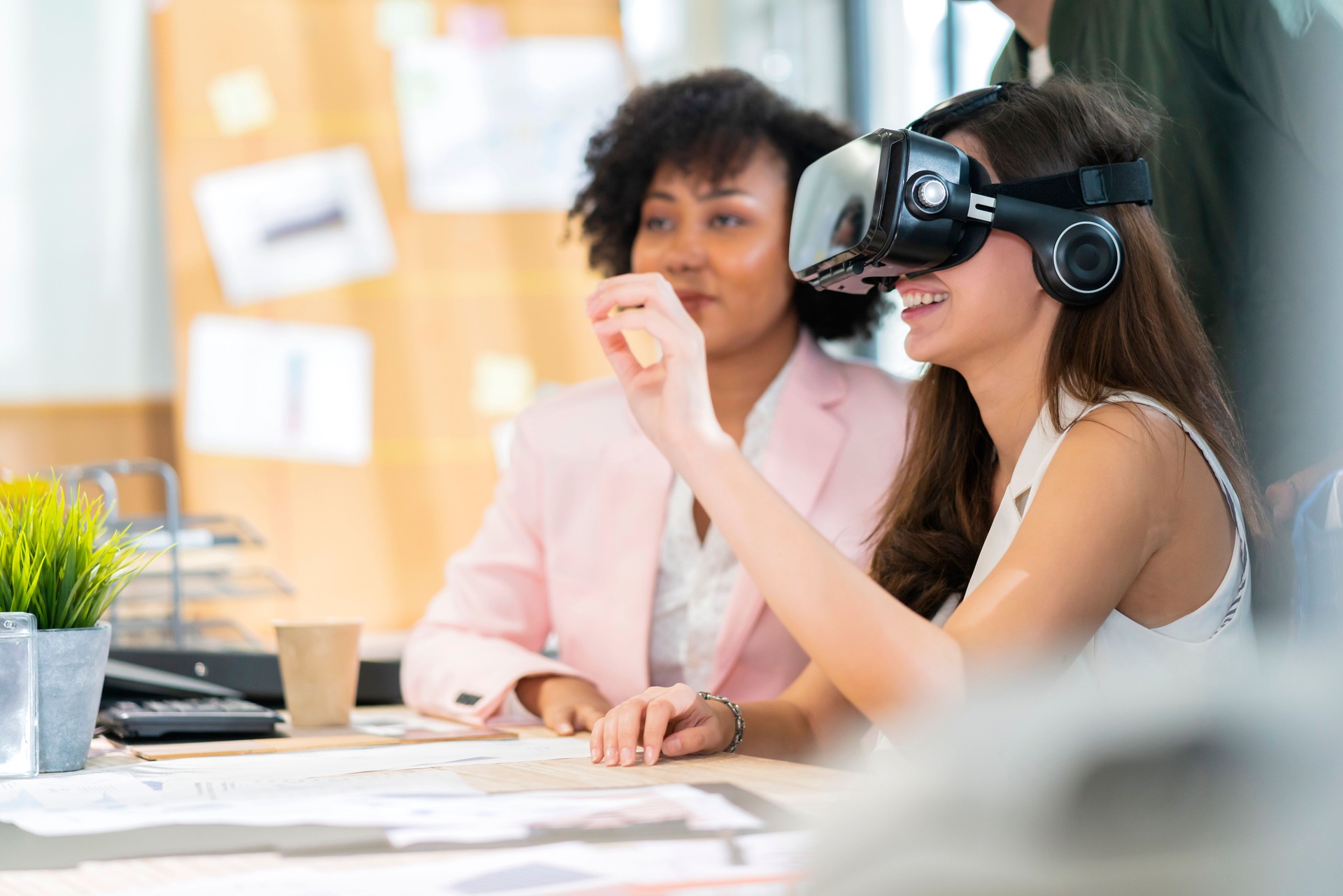 group of millennial male and female multiethnic using vr goggle to test metaverse meeting system cheerful and smiling,office friend standing discussion together next to window office background